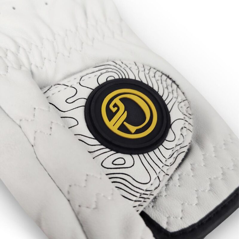 Close-up of a white quilted glove with a black-and-yellow circular brand emblem on the wrist strap.